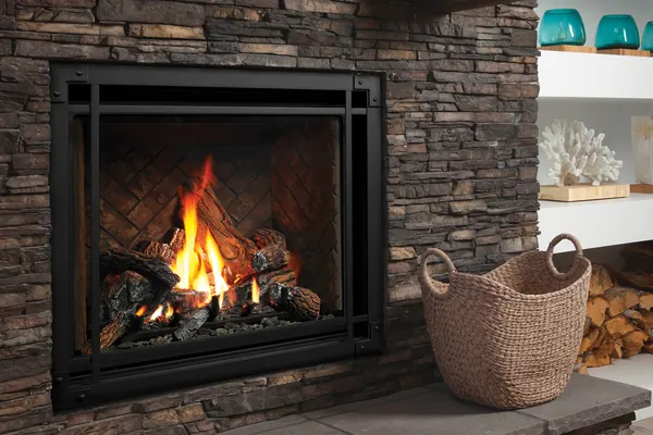 Traditional gas fireplace with burning logs, dark stone surround and white display shelves.