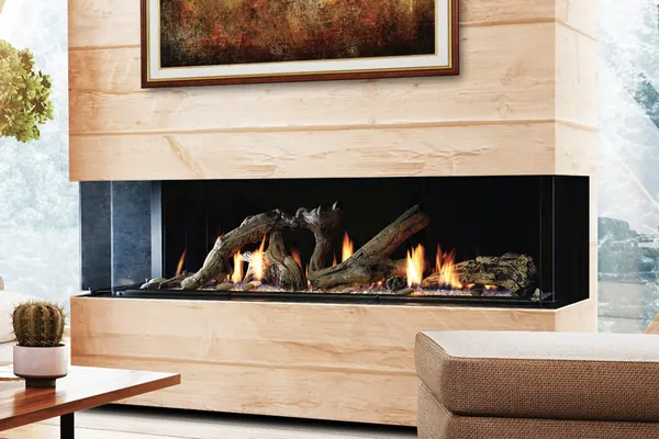 Wide linear gas fireplace with driftwood-style logs in a light stone living-room wall.