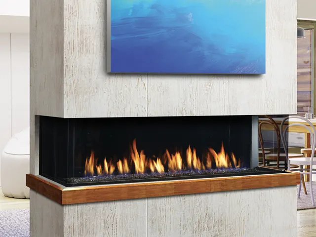 Three-sided linear gas fireplace in a light concrete divider between living and dining areas.